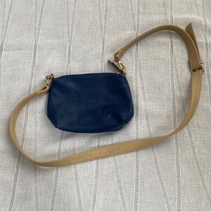 Charming Charlie small blue crossbody bag with tan strap.